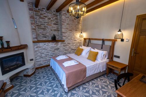 a bedroom with a bed in a room with a fireplace at Nostos Country House in Tsagarada
