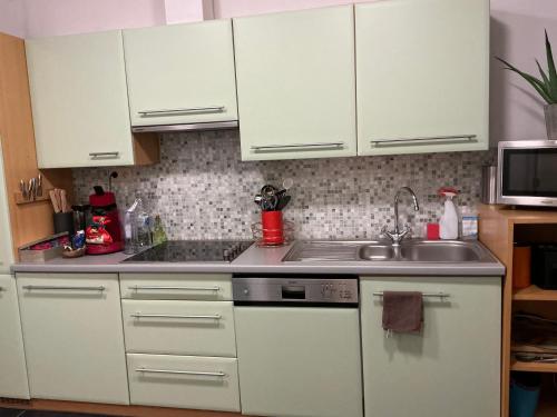 a kitchen with white cabinets and a sink at Aura Diest in Diest