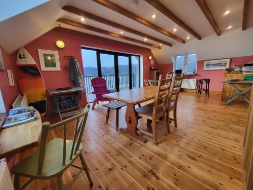 a dining room with a wooden table and chairs at The Boat House Waterside Home in Adrigole