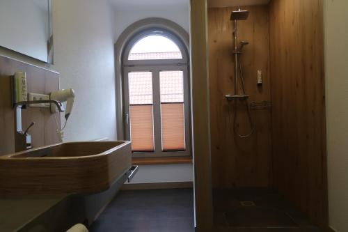 a bathroom with a sink and a window at LUXUS Hostel Rabe in Mühlhausen