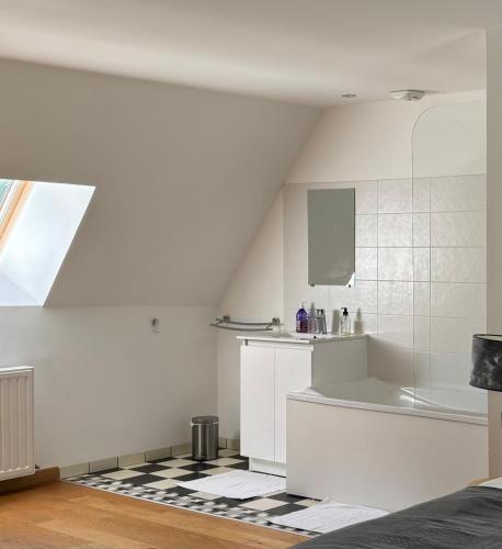 La salle de bains blanche est pourvue d'un lavabo et d'une baignoire. dans l'établissement Domaine des Annouillards, à Sornac