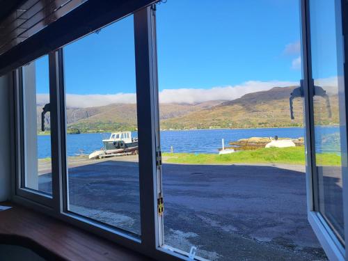 a window with a view of a body of water at The Boat House Waterside Home in Adrigole