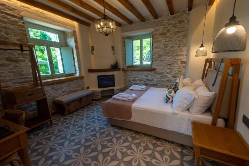 a bedroom with a bed and a fireplace at Nostos Country House in Tsagarada