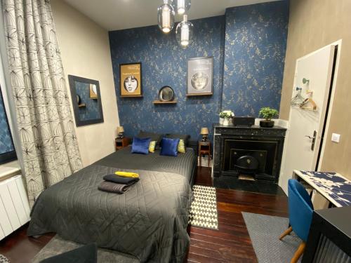 - une chambre avec un lit aux murs bleus et une cheminée dans l'établissement Studio chic & romantique, à Caluire-et-Cuire