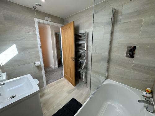 a bathroom with a tub and a sink and a shower at Wisteria House 3 bed sleeps 6 in Camelford