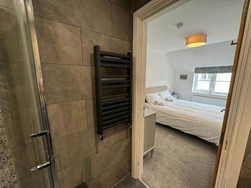 a small bedroom with a bed and a glass door at Wisteria House 3 bed sleeps 6 in Camelford