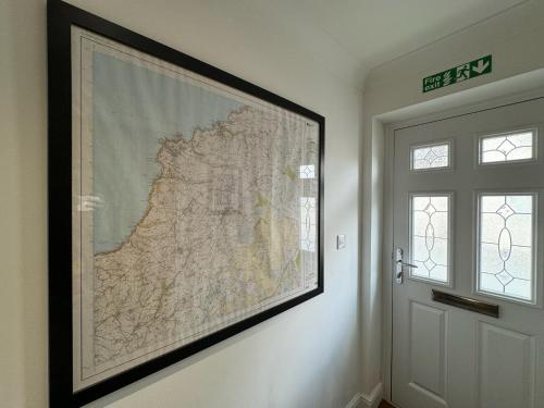 a large map hanging on a wall next to a door at Wisteria House 3 bed sleeps 6 in Camelford