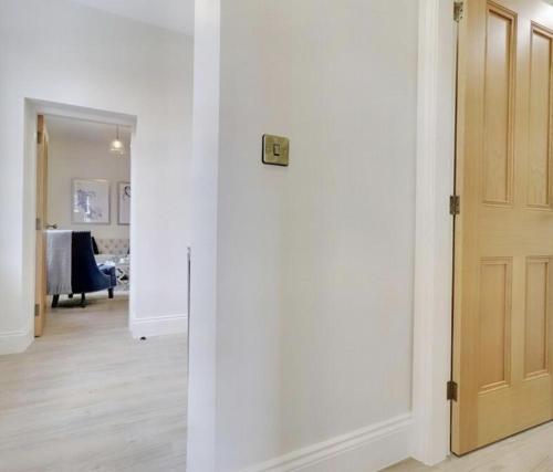 a hallway with a white wall and a door at The Wellington Suite, Garrick House in Lichfield