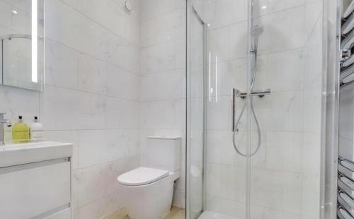 a white bathroom with a shower and a toilet at The Wellington Suite, Garrick House in Lichfield