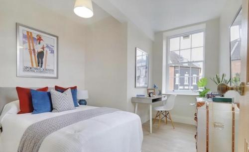 a bedroom with a bed and a desk and windows at The Wellington Suite, Garrick House in Lichfield