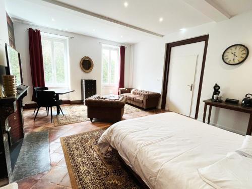 une chambre avec un lit et un salon avec une horloge dans l'établissement Dejean Vintage-wifi-centre-ville-Vélo, à Castelnaudary