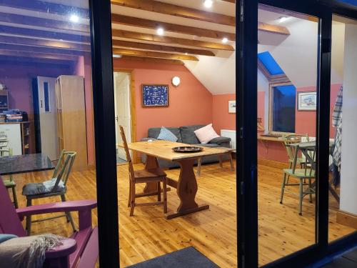a dining room and living room with a table at The Boat House Waterside Home in Adrigole