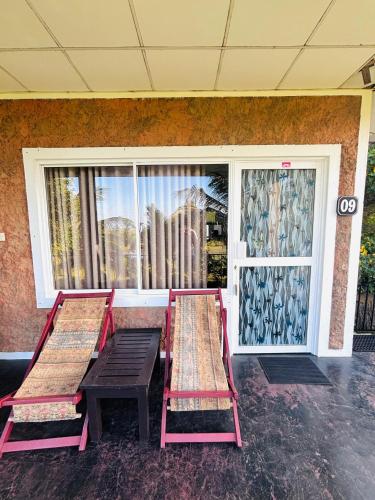 two benches in front of a building with a window at Werala Beach Resort in Kalpitiya