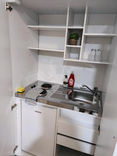 a small kitchen with a sink and a stove at Luxurious 3 bed Ensuites & kitchenettes Nr LGI Hospital & Uni - Free 5G WIFI & Netflix Short Stays - Contractors Free Parking in Leeds