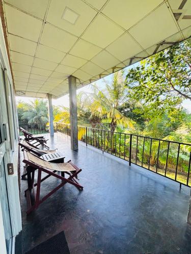 a porch with picnic tables and a railing at Werala Beach Resort in Kalpitiya