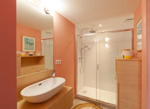 une salle de bains avec un lavabo blanc et une douche dans l'établissement Un duplex à la mer, à La Baule