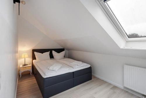 a small bedroom with a bed in a attic at Ferienwohnung Leuchtfeuer in Brodten