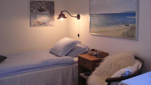 a bedroom with a bed and a night stand with a lamp at Ängshyddan B&B in Yngsjö