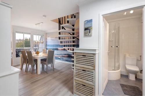 a kitchen and dining room with a table and a bathroom at Ferienwohnung Leuchtfeuer in Brodten