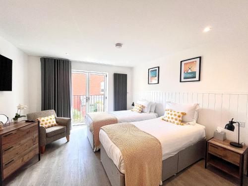 a hotel room with two beds and a chair at Mode Cottage in Lytham St Annes