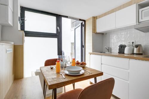 une petite cuisine avec une table et des chaises en bois dans l'établissement 204 Suite Coco - Superb apartment in Paris, à Paris
