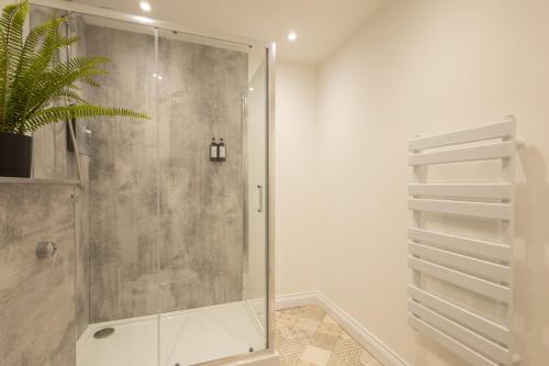 a shower with a glass door in a bathroom at Apartment 1, King's Court in Scarborough