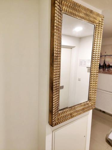 a mirror with a wicker frame on a wall at Luxurious 3 bed Ensuites & kitchenettes Nr LGI Hospital & Uni - Free 5G WIFI & Netflix Short Stays - Contractors Free Parking in Leeds