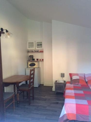 une chambre avec un lit, un bureau et une table dans l'établissement petit logement coquet, à Avignon