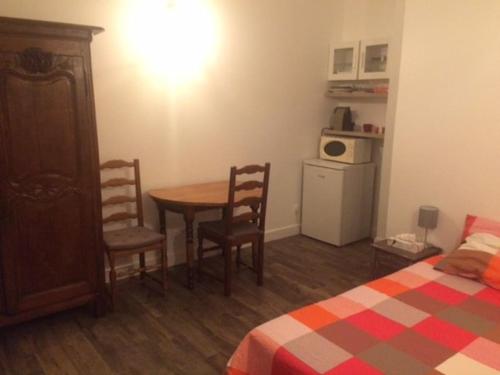 une pièce avec une table, des chaises et un lit dans l'établissement petit logement coquet, à Avignon
