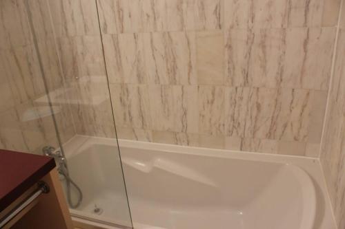 La salle de bains est pourvue d'une baignoire et d'une douche en verre. dans l'établissement Beau T3 avec piscine collective proche Port,plage et commerces-4JDN822, à Saint Cyprien Plage