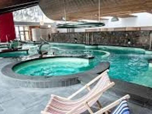 une grande piscine avec deux chaises dans un bâtiment dans l'établissement Studio Cabine Aux Angles avec Garage et Equipements Complets - FR-1-593-62, aux Angles