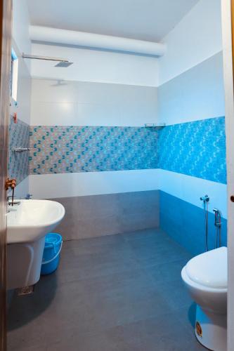 a bathroom with a white sink and a toilet at Marari Moriyah Homestay in Mararikulam