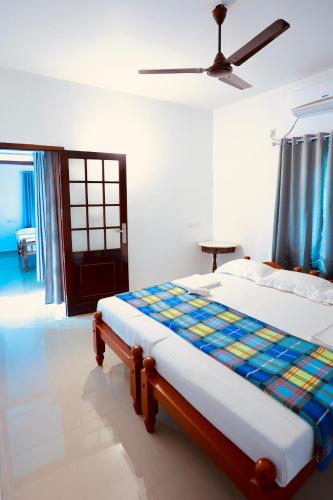 a bed in a white room with a ceiling at Marari Moriyah Homestay in Mararikulam