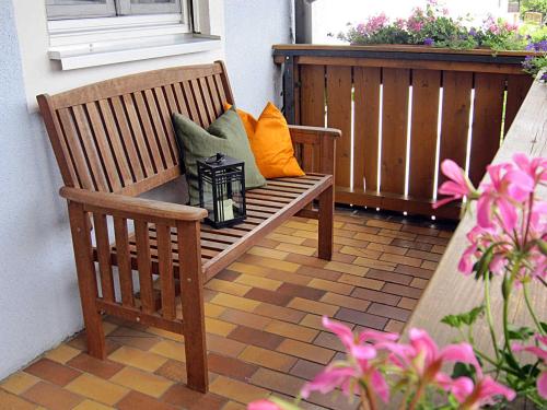 a wooden bench with pillows sitting on a balcony at Landurlaub Wittmann in Pegnitz