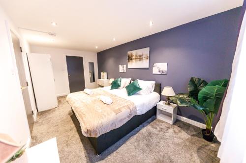 ein Schlafzimmer mit einem Bett und einer blauen Wand in der Unterkunft Stylish 6-Bedroom House, Ideal for Contractors! in Monkwearmouth