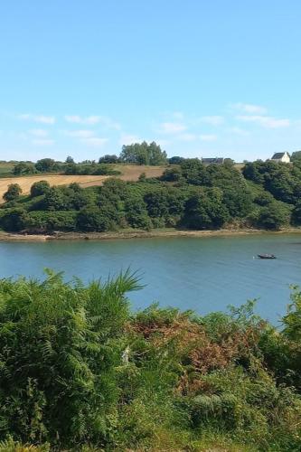 a river with a boat in the middle of it at Villa pour 6 pers - vue mer - 5 min d'un site magnifique - Lanmodez - Paimpol, Côtes d'Armor, Bretagne in Lanmodez