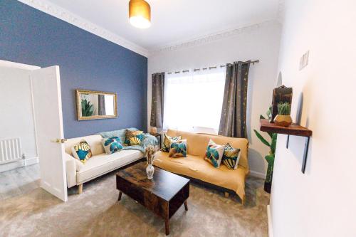 ein Wohnzimmer mit Sofa und Tisch in der Unterkunft Stylish 6-Bedroom House, Ideal for Contractors! in Monkwearmouth