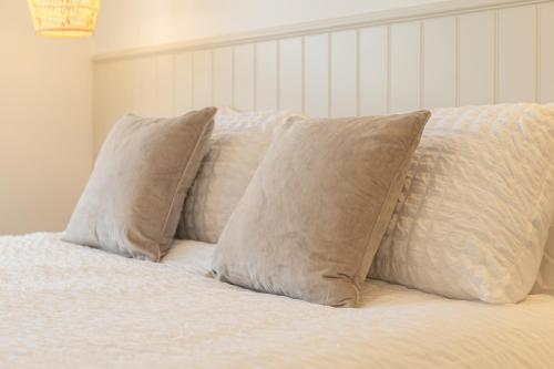 a bed with four pillows on top of it at Apartment 2, King's Court in Scarborough