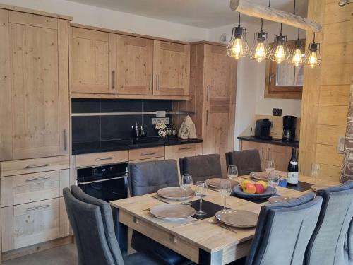 une cuisine avec une table en bois et des chaises ainsi qu'une salle à manger dans l'établissement Appartement luxueux 3 pièces, spa privé, skis aux pieds - FR-1-810-21, aux Saisies