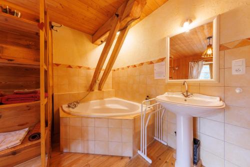 une salle de bain avec un lavabo et une baignoire dans l'établissement Moulin du Bateau - Gîte de Charme - Piscine - Nature, à Léotoing