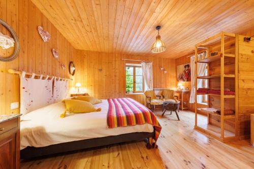 une chambre avec un lit et un plafond en bois dans l'établissement Moulin du Bateau - Gîte de Charme - Piscine - Nature, à Léotoing