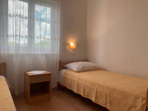mała sypialnia z łóżkiem i oknem w obiekcie Apartments Nevenka P. w mieście Šilo
