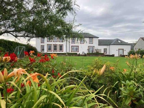 a large white house with flowers in front of it at Watchhall, Annan, Dumfries & Galloway, Scotland Barn - 2 Bed in Annan