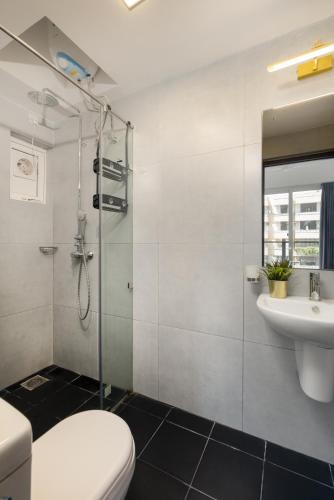a bathroom with a shower and a toilet and a sink at Pendennis Fern - 4-Bedroom Luxury Retreat with Rooftop Pool in Central Colombo in Colombo