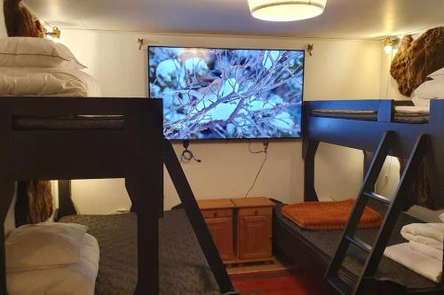 a room with a large screen tv and a bunk bed at Villa The White Moose, 6 rooms, 3 bedrooms, 2,5 baths, sauna, near Branäs in Likenäs