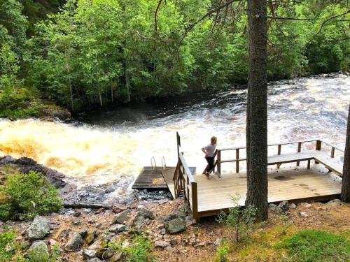a person standing on a wooden bridge over a river at Villa The White Moose, 6 rooms, 3 bedrooms, 2,5 baths, sauna, near Branäs in Likenäs