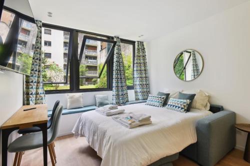 une chambre avec un lit, un bureau et des fenêtres dans l'établissement 312 Suite Lisa - Superbe Appartement à Paris, à Paris