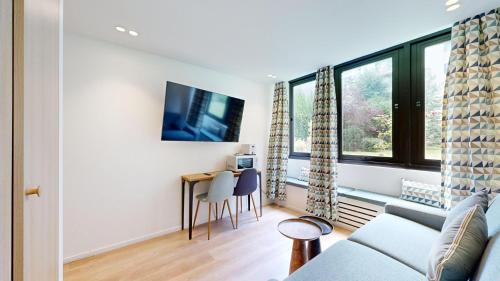 un salon avec un canapé et une table avec des chaises dans l'établissement 312 Suite Lisa - Superbe Appartement à Paris, à Paris