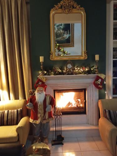 a santa claus statue in a living room with a fireplace at Three Goods Trikala Meteora in Tríkala