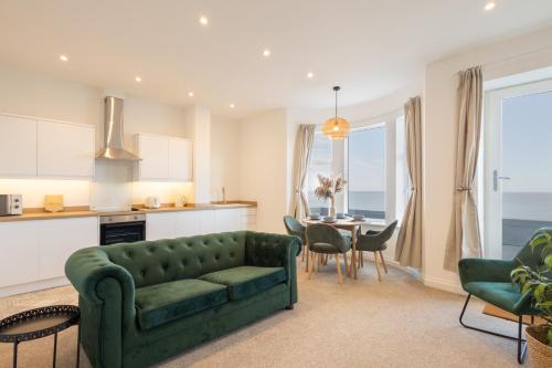 a living room with a green couch and a table at Apartment 3, King's Court in Scarborough
